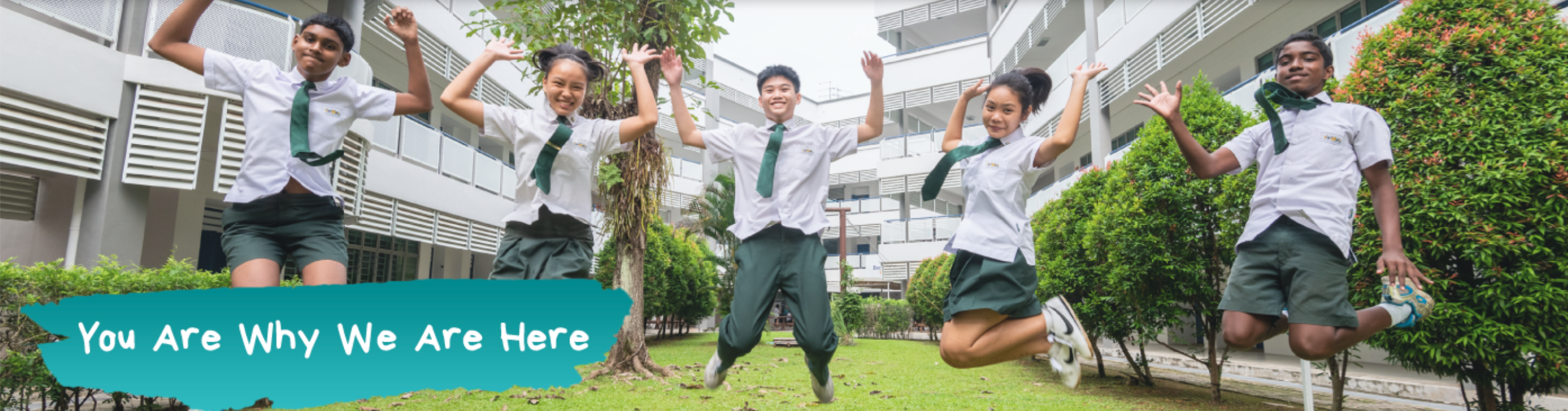 Five students in white and green school uniforms jump joyfully outdoors with text "You Are Why We Are Here."